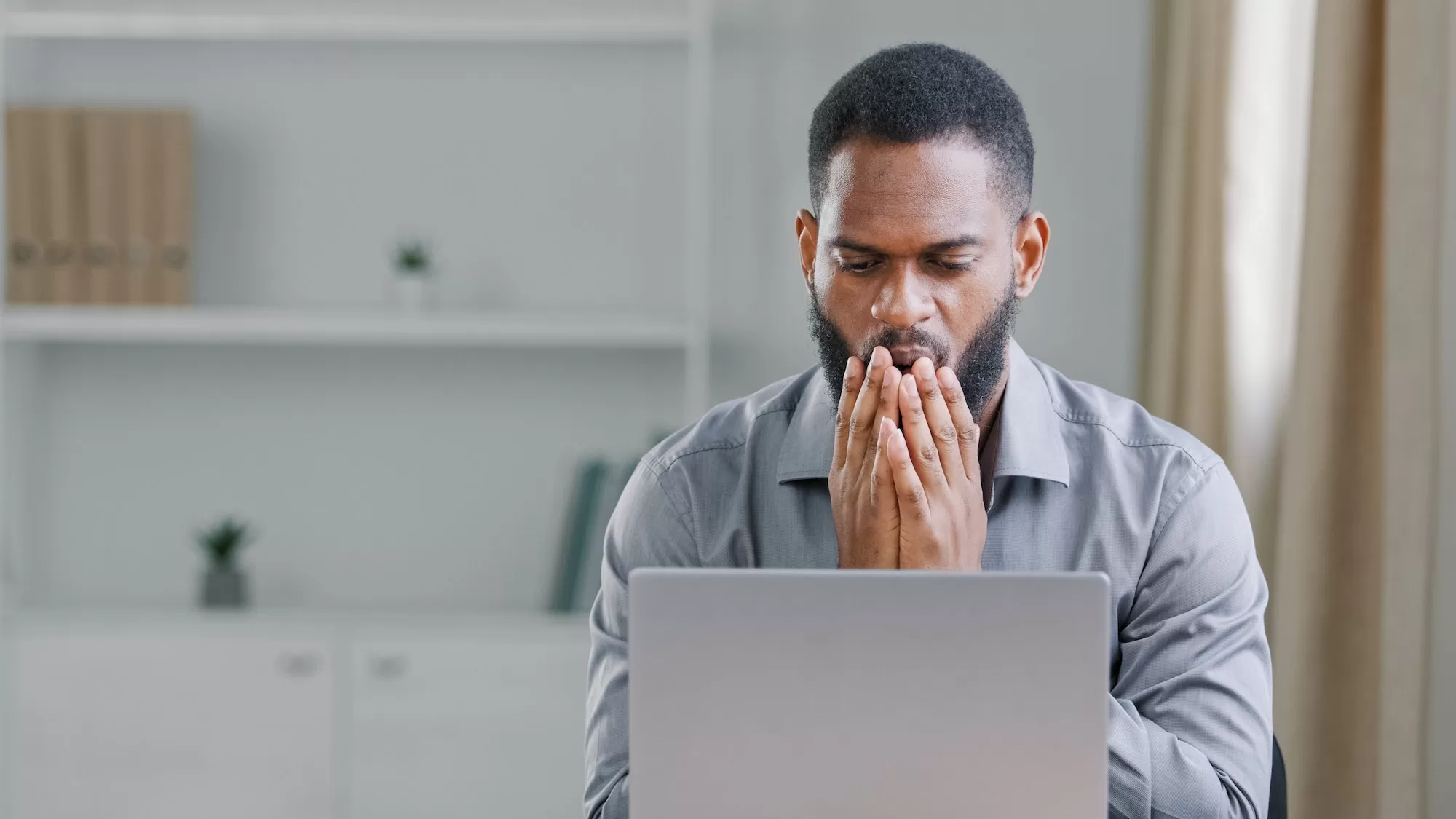 Depressed african man frustrated after reading bad news about SASSA expired cards