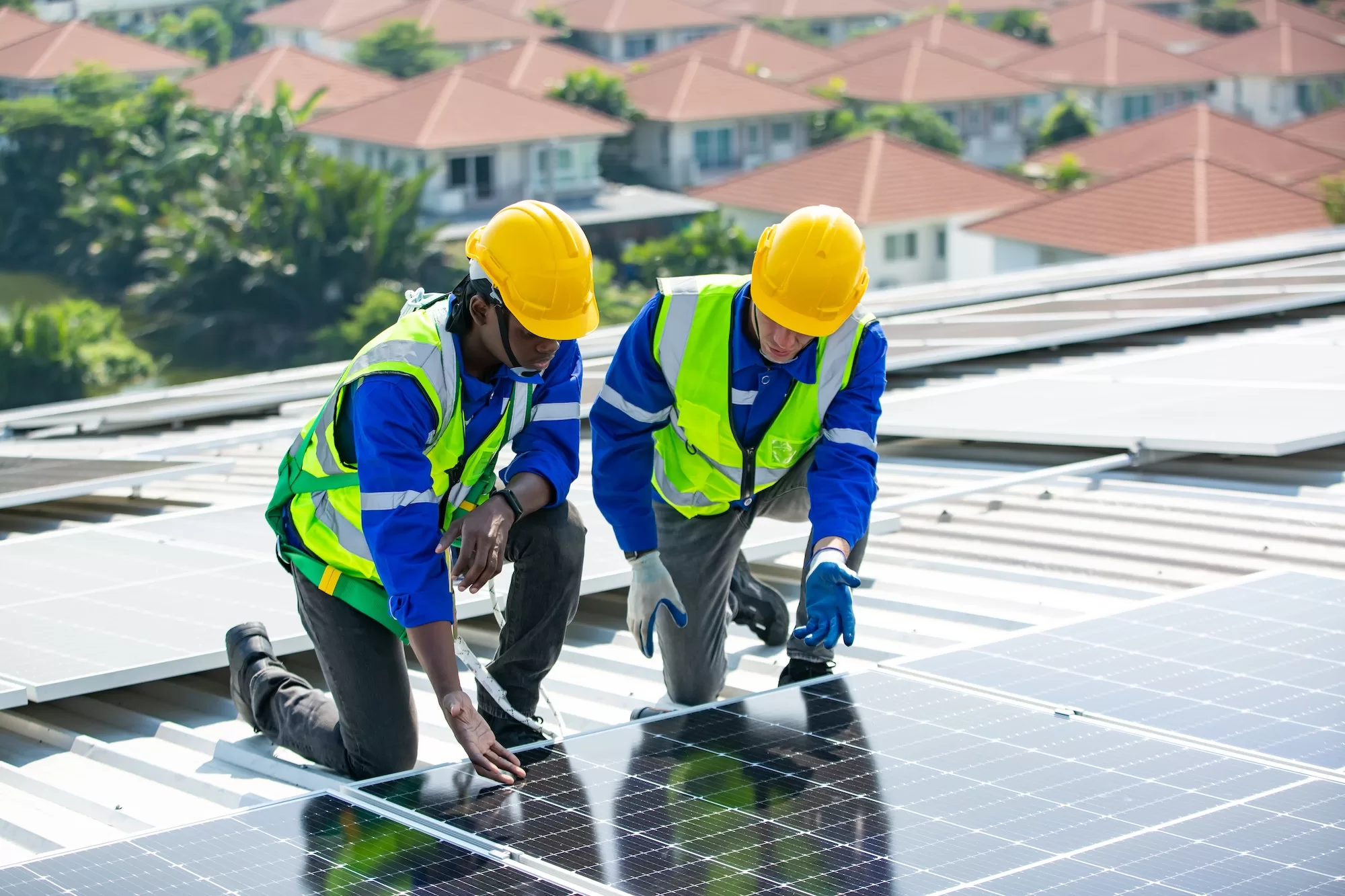 Solar panel installer installing solar panels on roof of warehouse | Bright Savings: Understanding Solar Panel Tax Incentives for Individuals and Businesses