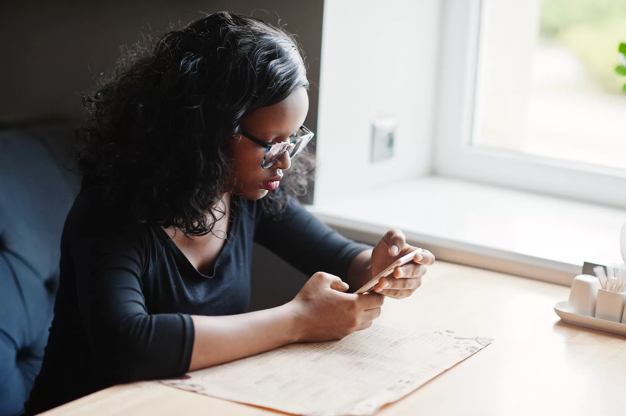 Africa woman at restaurant going through the Application Process and Mandatory Documents to become the Regional IT Officer for the Namibian Census 2023