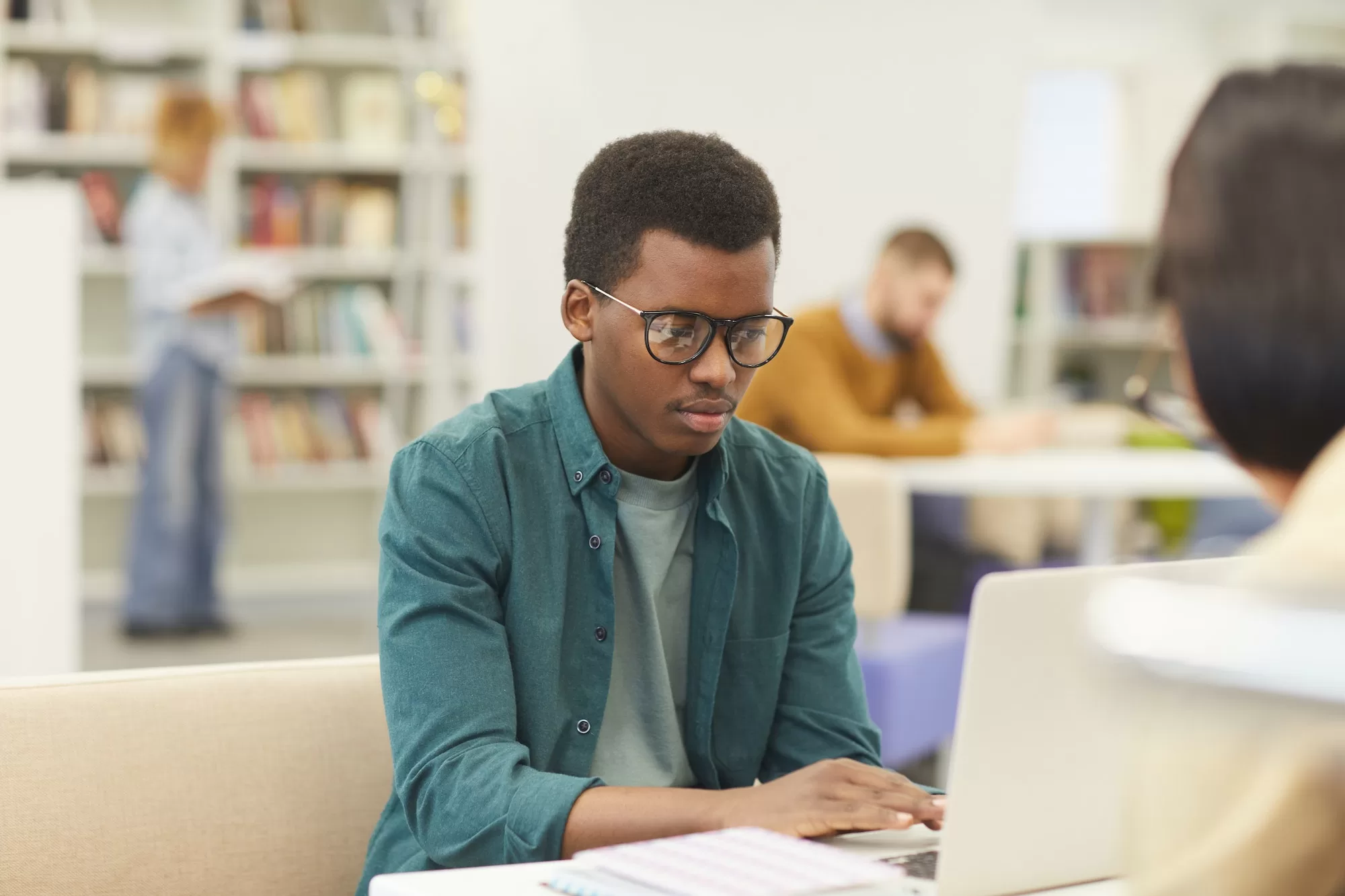 PwC bursary Student Using Laptop in Library | PwC Bursaries
