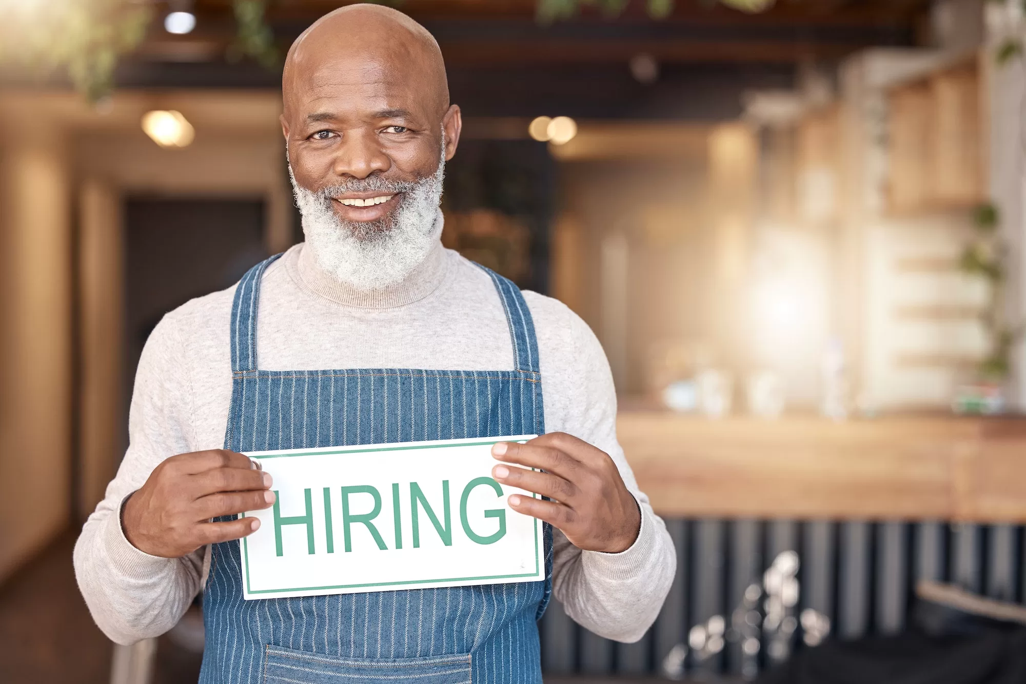 Black man, hiring sign and portrait smile in small business for recruitment, hire or job opportunity | Navigating the Challenging South African Job Market: Insights and Strategies