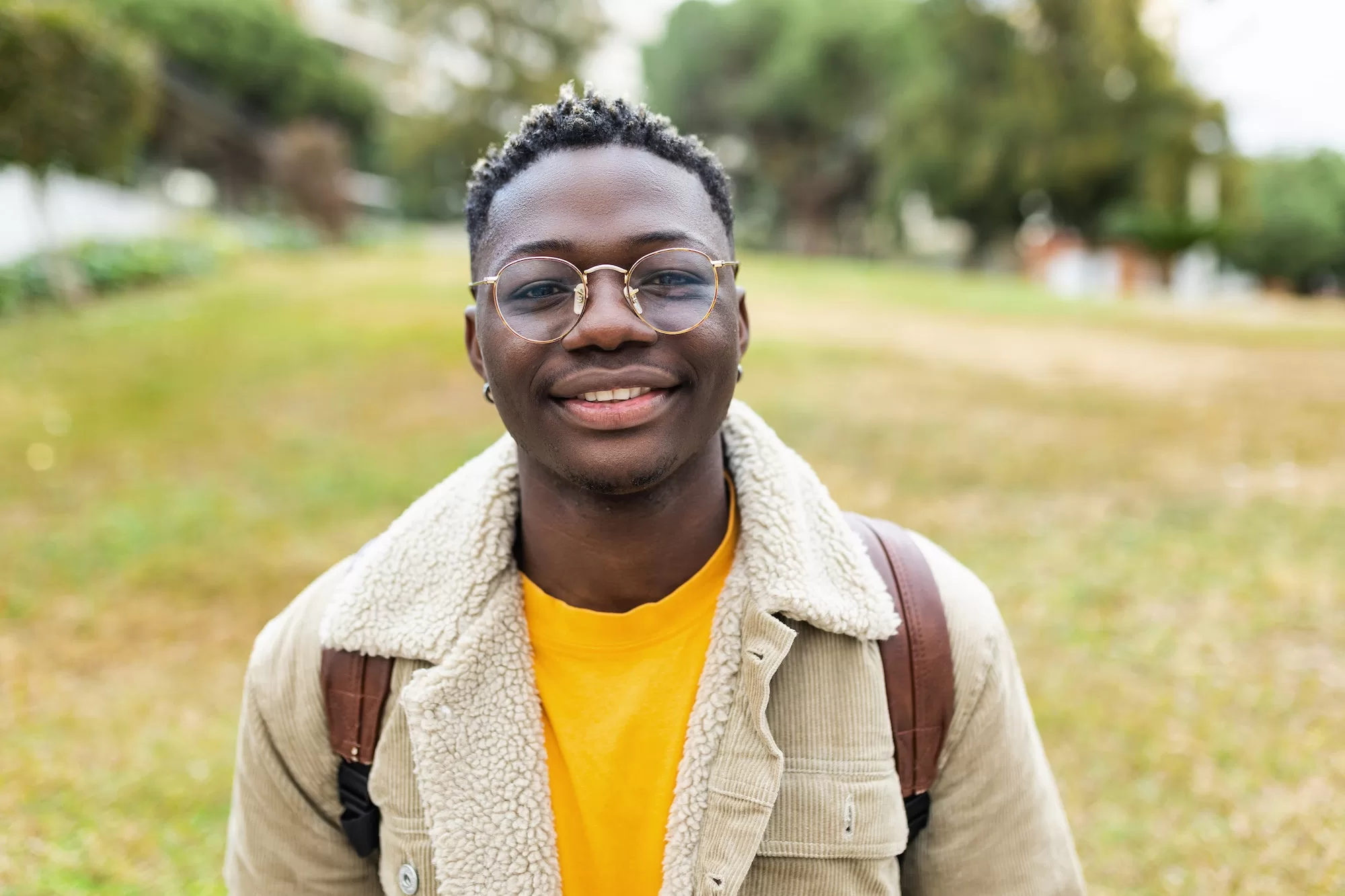 Smiling african young student man looking at camera outdoors | NCE Bursary in Namibia
