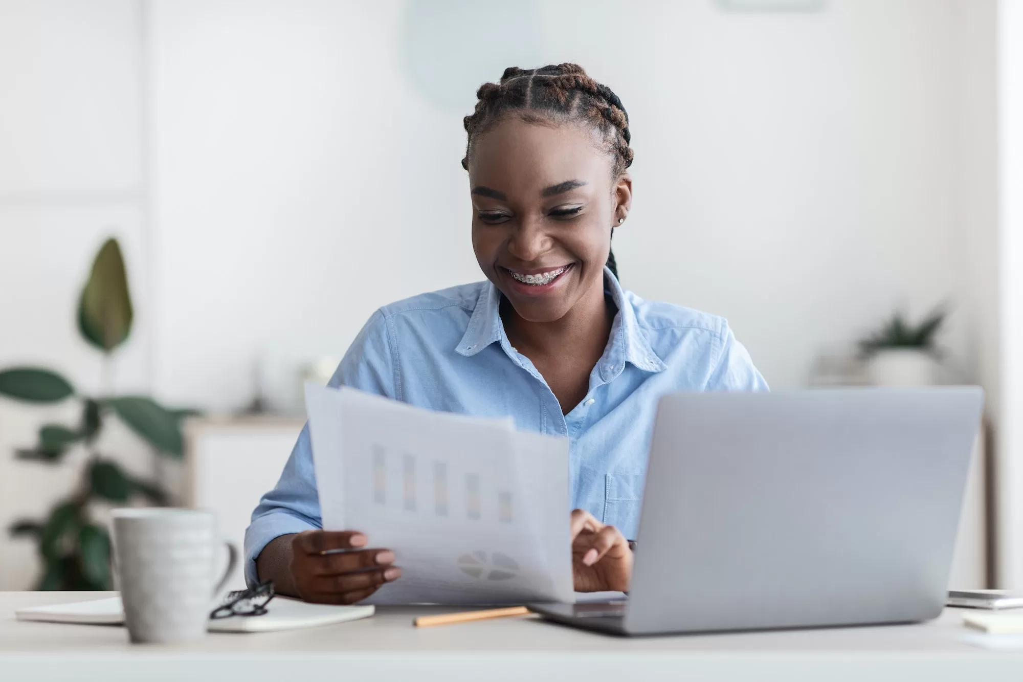 Young African Businesswoman Working With NAMRA Abbreviations Documents At Desk In Modern Office