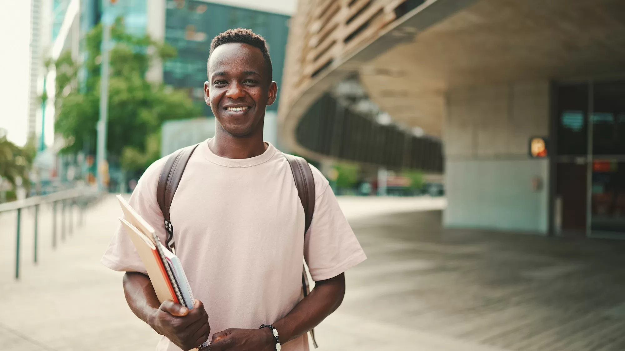 Young african student stands outside of university, looks at the camera, smiles after getting Nedbank Namibia Bursary