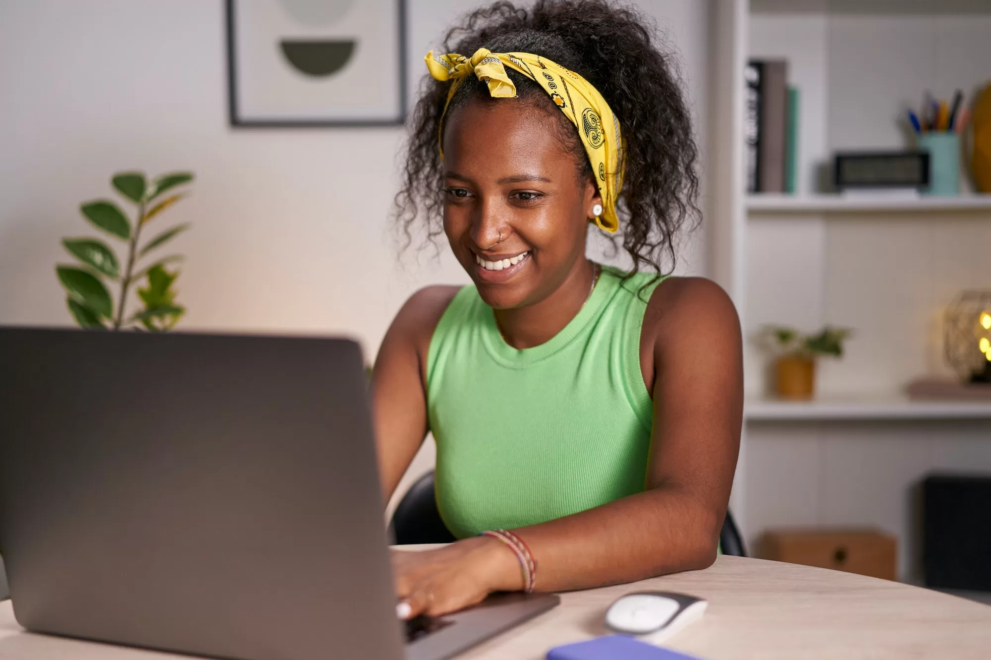 Young African woman using laptop in home office. Happy girl typing an Effective CV in the Namibian Census recruitment.