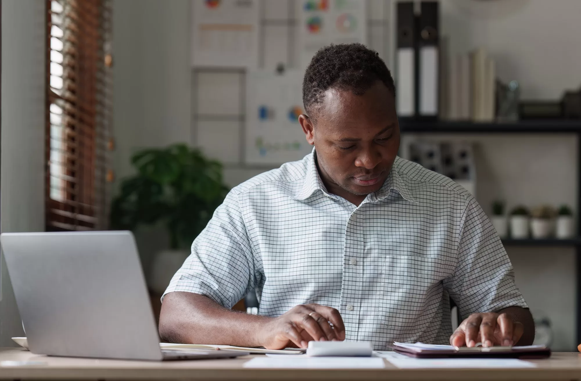Submitting VAT Returns through the ITAS Portal: Accountant African man using calculator with document, tax, exchange, accounting and