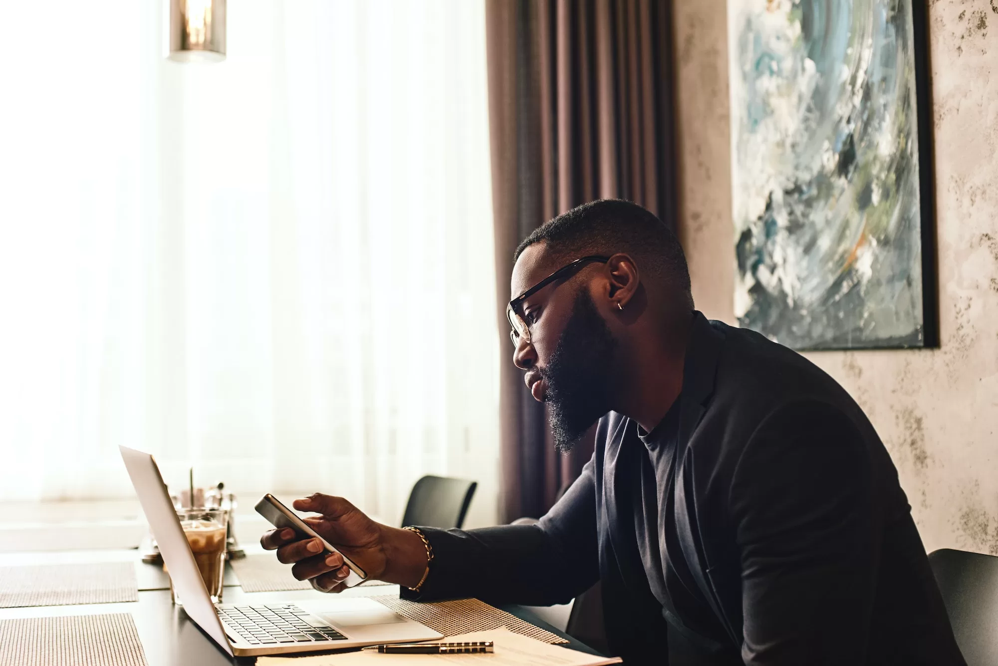 The Roadmap to Success: PAYE Returns Steps to Online Submission - African businessman is working, using his laptop while resting in the cafe. Side view
