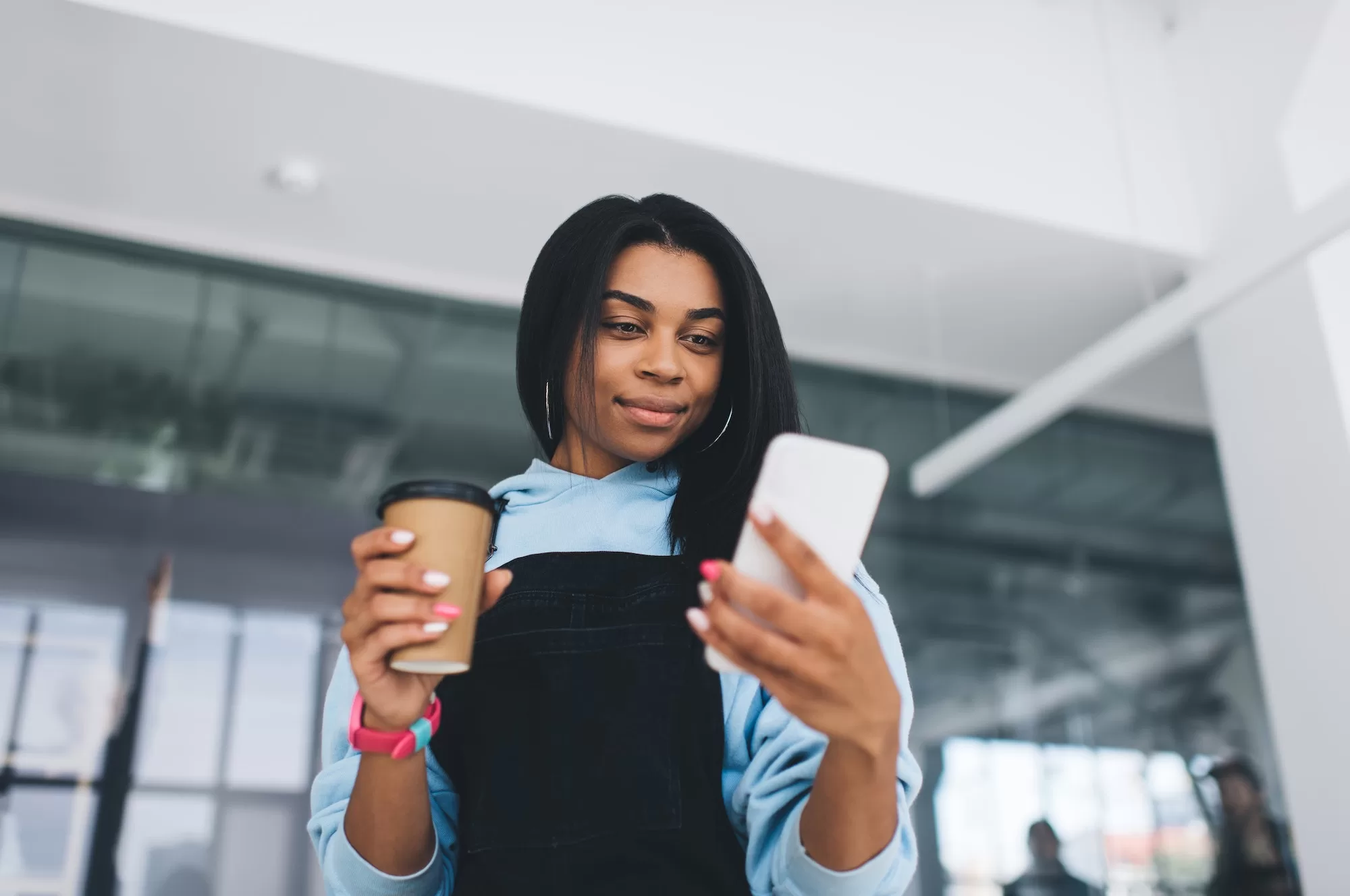 Unveiling the 14 Day Jiva Package. African girl using smartphone and drinking coffee