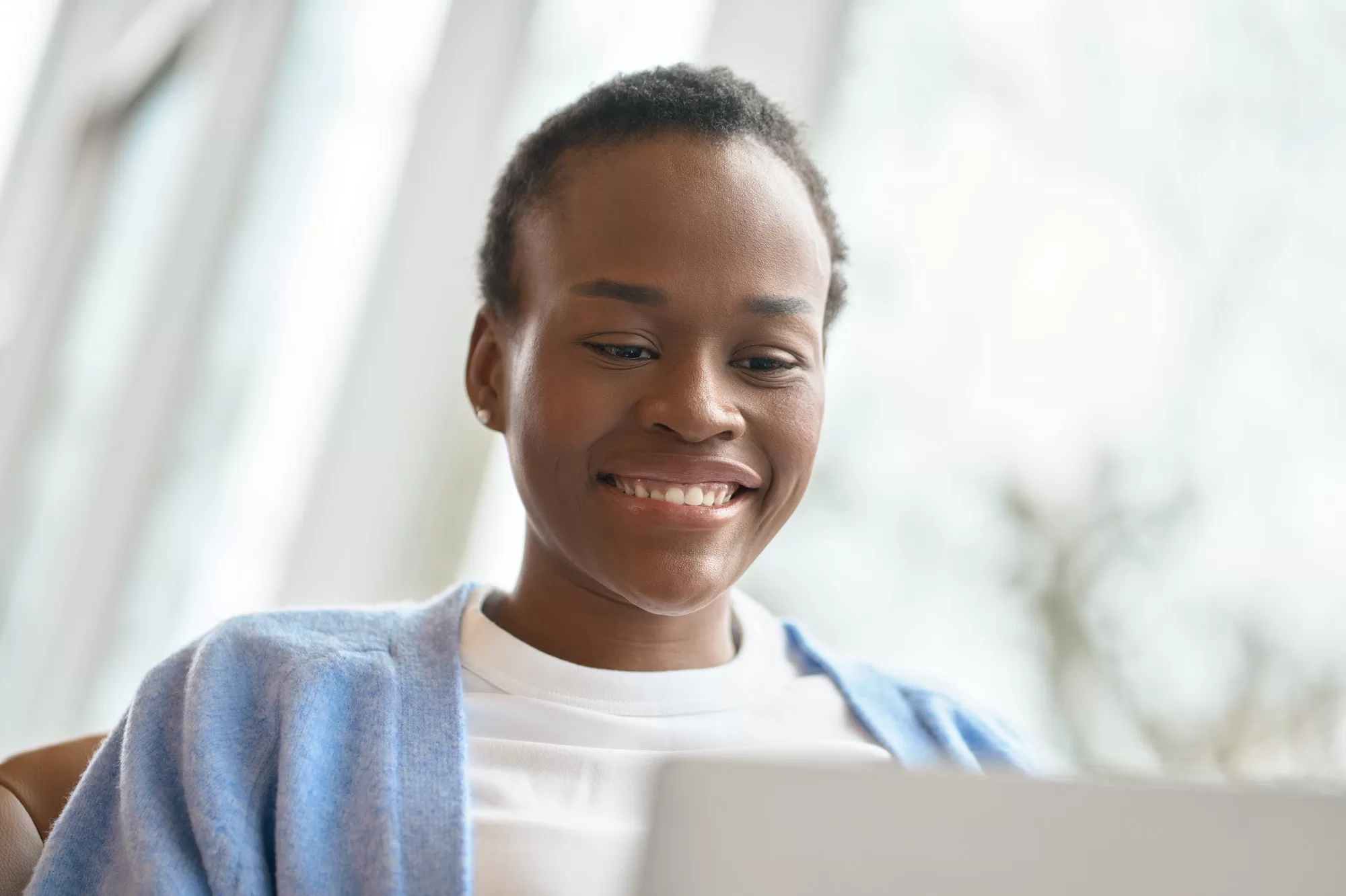 Unveiling the Integrated Tax Administration System Experience: Benefits and Features - Happy African Black girl student using laptop looking at computer. Close up