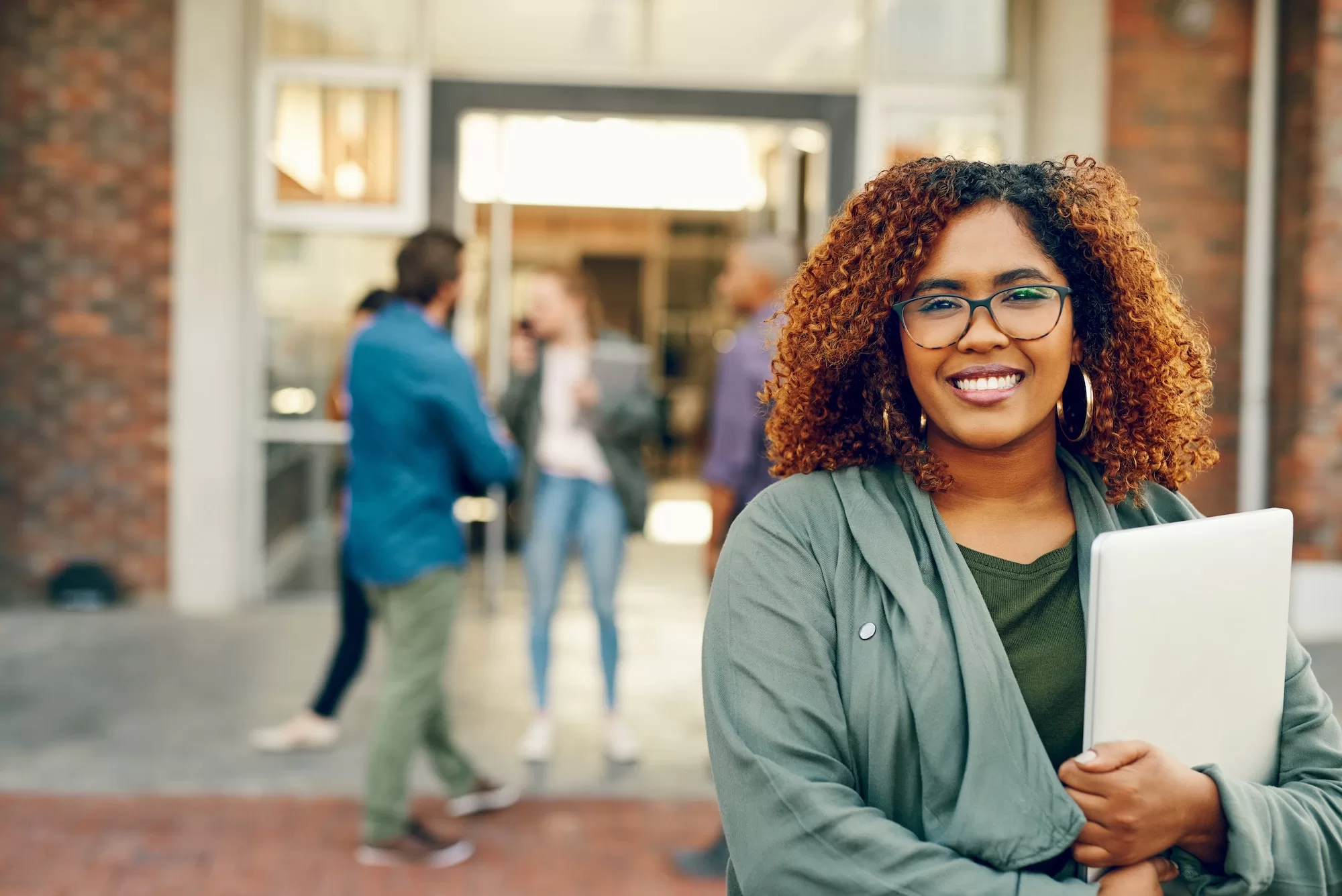 NUST 2023: Demystifying NUST FEES - How to Manage Costs and Excel in Your Education : Portrait of a happy young woman holding a laptop outdoors on campus