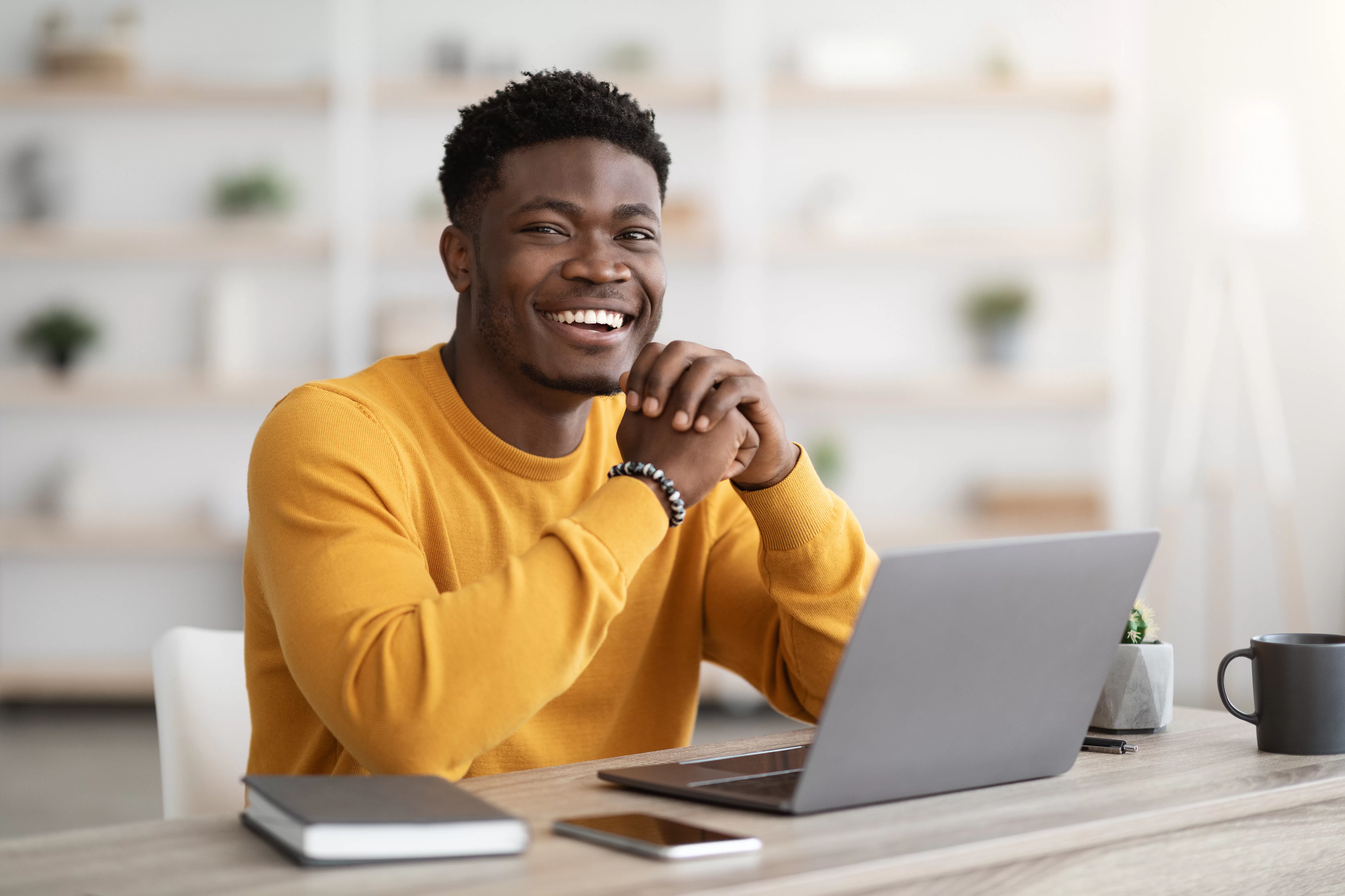 Black man freelancer sitting at workdesk at home, using laptop. Daily Transcription: Your Gateway to Online Transcription Jobs in Namibia Without Interviews