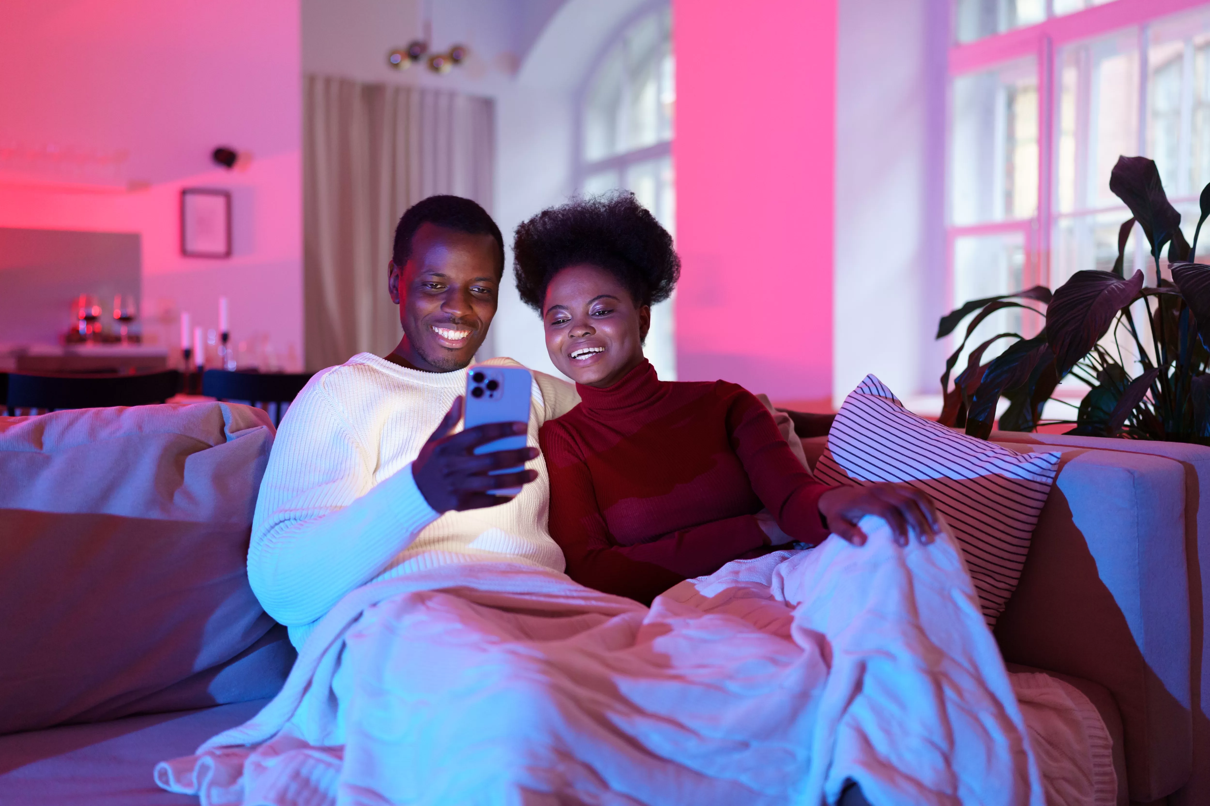 African couple relax on sofa with smartphone at home, friends watch funny videos on mobile phone. Your Path to Profits Awaits: Make money watching YouTube videos